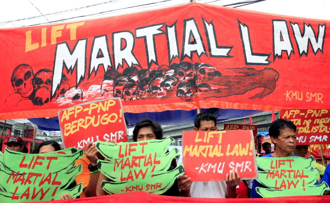 Người biểu tình giương biểu ngữ đòi bỏ lệnh thiết quân luật trước dinh tổng thống ở thủ đô Manila, ngày 18-7 - Ảnh: Reuters