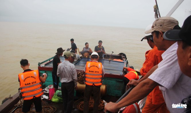 Lực lượng cứu hộ, cứu nạn phải đưa đội thợ lặn qua một thuyền nhỏ của ngư dân và xuống cứu hộ - Ảnh: DOÃN HÒA