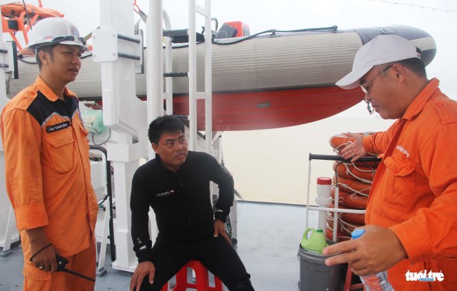Đại diện Trung tâm phối hợp tìm kiếm cứu nạn trao đổi với thợ lặn về phương án tìm nạn nhân - Ảnh: DOÃN HÒA