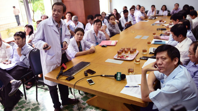Thứ trưởng Nguyễn Thanh Long (phải) đang lắng nghe báo cáo diễn biến bệnh sốt xuất huyết - Ảnh: HỮU THUẬN