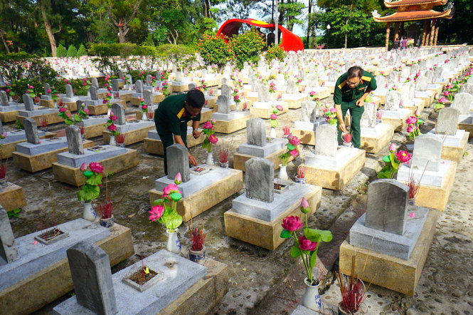 Thắp hương các ngôi mộ tại Nghĩa trang liệt sĩ quốc gia Trường Sơn chiều 19-7 - Ảnh: QUANG ĐỊNH