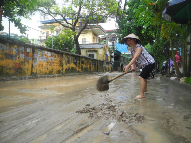 Nhiều người dân dùng chổi, xẻng quét nước, dọn bùn trên đường