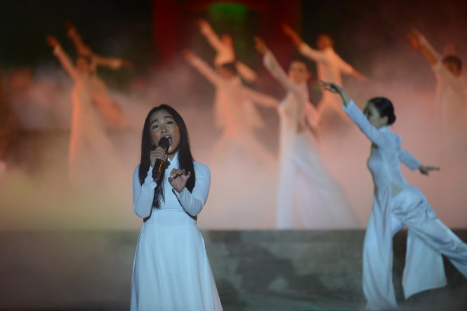Ca sĩ Đoan Trang và tốp ca nữ sinh viên Quảng Trị trình diễn ca khúc Bài ca không quên - Ảnh: QUANG ĐỊNH