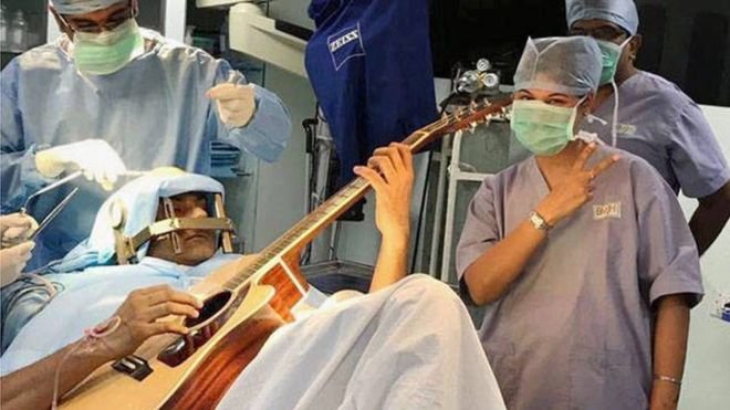 Abishek chơi đàn trong khi các bác sĩ đang mổ cho ông - Ảnh: PTI
