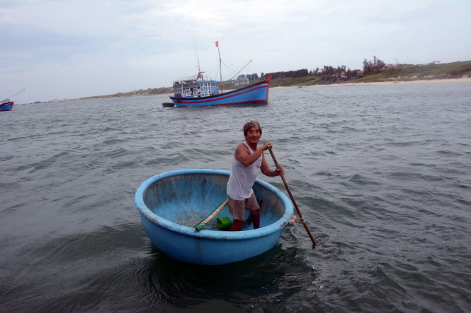 Ông Ba Hùng chèo thuyền thúng đón khách thăm Hòn Cau - Ảnh: ĐỨC TRONG