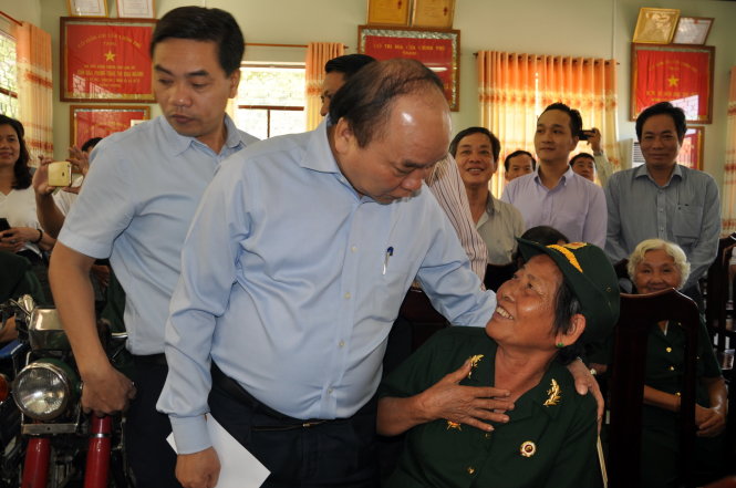Thủ tướng Nguyễn Xuân Phúc ân cần hỏi thăm một nữ thương binh - Ảnh: ĐÔNG HÀ