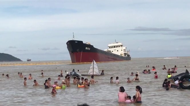 Du khách tắm biển gần tàu Thái Hà 26 bị mắc cạn ở bãi biển Cửa Lò, Nghệ An - Ảnh: DOÃN HÒA