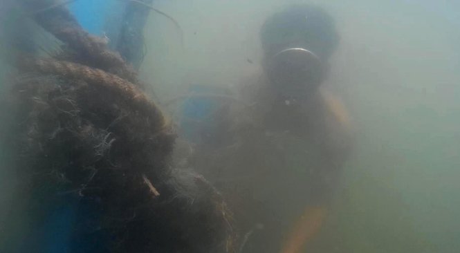Ngư dân phải lặn xuống đáy vịnh Hòn La tìm xác tàu chìm để vớt những gì còn dùng được - Ảnh: Quốc Nam