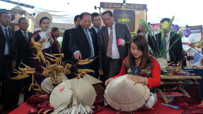 Ông Tất Thành Cang và bí thư - tỉnh trưởng Champasak Bounthong Divixay tham quan gian hàng nón lá tại “Những ngày TP.HCM tại Champasak” - Ảnh: M.Hoa