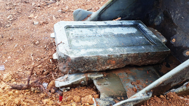 Tấm bia đá trên ngôi mộ được xác định của vợ vua Tự Đức bị san ủi làm bãi đỗ xe - Ảnh: NHẬT LINH