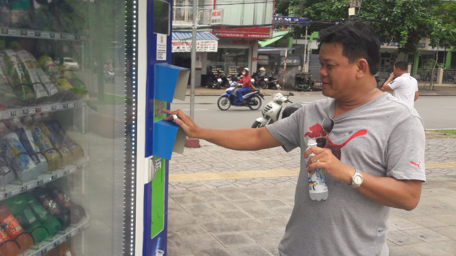 Mua nước giải khát bằng máy bán hàng tự động tại công viên Lưu Hữu Phước (Q. Ninh Kiều) - Ảnh: LÊ DÂN