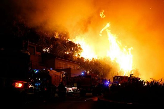 Lính cứu hỏa đang ra sức dập tắt đám cháy ở Biguglia, gần Biguglia, đảo Corsica, Pháp - Ảnh: AFP