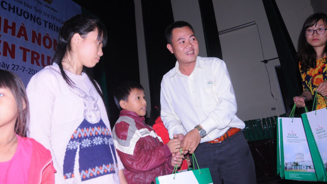Đại diện hội nông dân tỉnh và công ty Green Feed trao quà cho các em học sinh - Ảnh: LÂM THIÊN