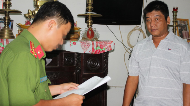 Công an đọc lệnh bắt tạm giam ông Bùi Văn Minh - Ảnh: Phan Tại