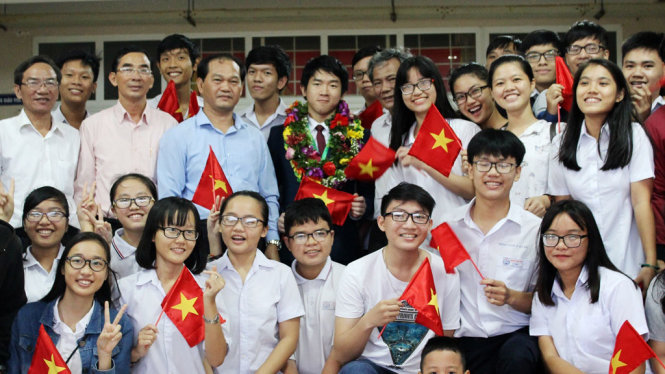 Quốc Huy (đứng giữa, đeo vòng hoa) cùng người thân, thầy cô và bạn bè trong lễ đón tại Trường THPT chuyên Lê Quý Đôn chiều 25-7 - Ảnh: MẠNH KHANG