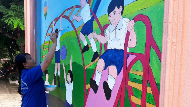 Chiến sĩ Lê Thị Yến Thanh thực hiện vẽ trang trí trường mầm non tỉnh Champasak - Ảnh: QUANG PHƯƠNG