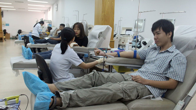 Bạn Quang Huy (20 tuổi) đi cùng ba mình đến hiến máu chia sẻ với bệnh nhi ung thư - Ảnh: MINH PHƯỢNG
