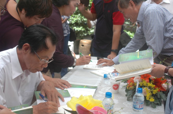 Bác sĩ Trần Văn Bản và nhà văn Nguyễn Thị Ngọc Hải ký tặng sách - Ảnh: MAI THỤY