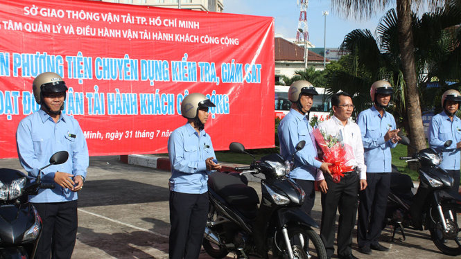 Ông Trần Chí Trung (áo trắng) tặng hoa và chính thức phát động lễ ra quân kiểm tra xe buýt - Ảnh: THU DUNG