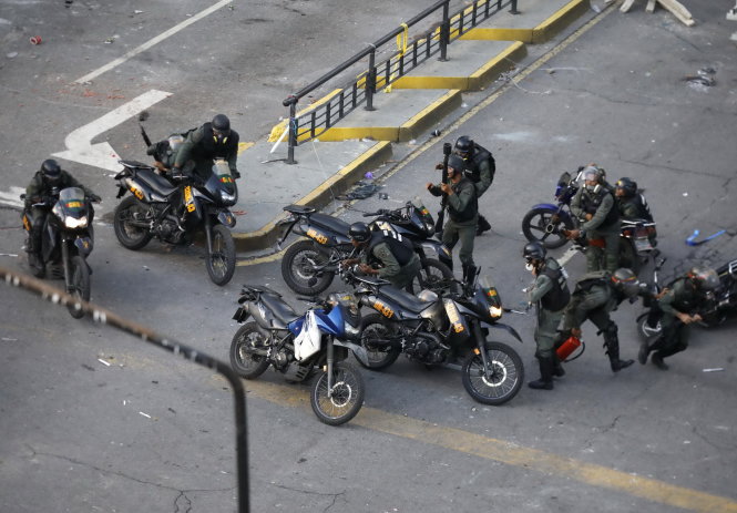 Cảnh sát chống bạo động của Venezuela đi môtô triển khai đội hình tại thủ đô Caracas - Ảnh: REUTERS