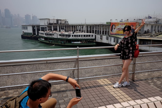 Du khách Trung Quốc chụp ảnh lưu niệm ở bến tàu Star Ferry tại Tsim Sha Tsui, Hong Kong - Ảnh: REUTERS