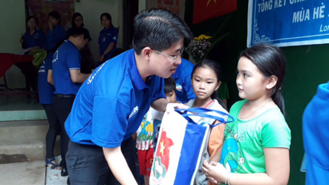 Ông Phạm Hồng Sơn tặng quà cho các em học sinh trường tiểu học xã Long Thới - Ảnh: LA MY