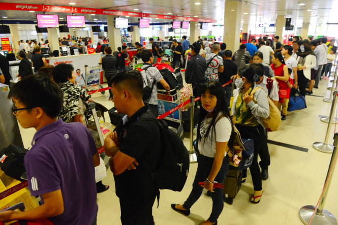 Hành khách làm thủ tục lên máy bay tại sân bay Tân Sơn Nhất - Ảnh: Quang Định