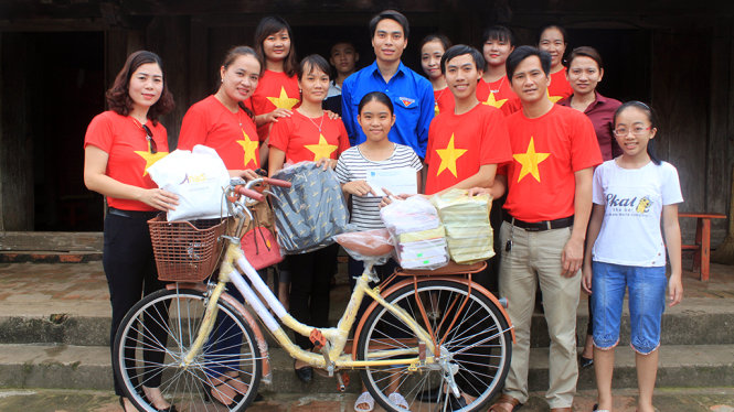 Các bạn trẻ trong CLB “Trái tim nhân ái huyện Thọ Xuân” trao tặng xe đạp, đồ dùng học tập cho em Nguyễn Thị Thao sáng 4-8 - Ảnh: Hà Đồng.