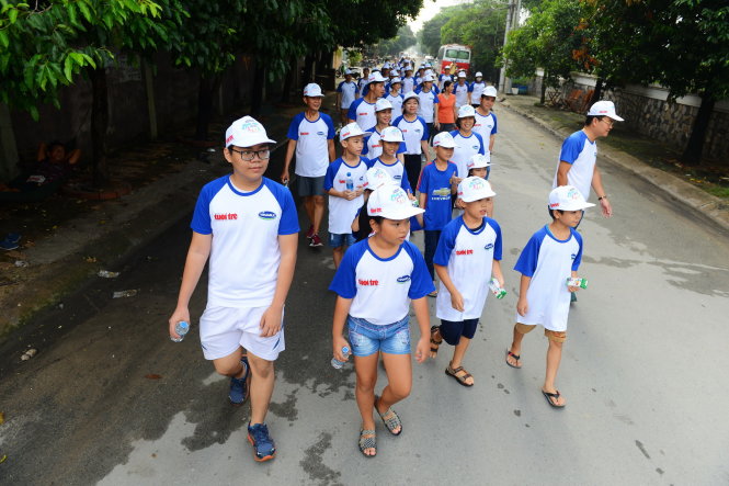 Các em nhỏ hăng hái tham gia đi bộ xung quanh khu căn hộ cao cấp Giai Việt trên đường Tạ Quang Bửu, Q.8, TPHCM sáng 6-8 - Ảnh: QUANG ĐỊNH