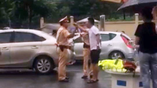 Người vi phạm (mặc áo trắng) cự cãi với cảnh sát giao thông - Ảnh cắt từ clip