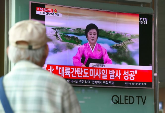 Người dân ở ga Seoul xem bà Ri Chun Hee thông báo tin bắn tên lửa liên lục địa hôm 4-7 - Ảnh: AFP