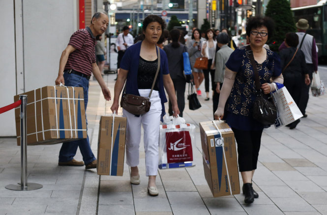 Du khách Trung Quốc mua sản phẩm bồn cầu ở Nhật Bản - Ảnh: Reuters