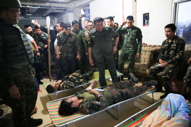 Tổng thống Duterte (giữa) thăm ủy lạo các binh sĩ Philippines bị thương trong cuộc chiến chống khủng bố được chữa trị tại trạm xá của căn cứ quân sự tại thành phố Marawi hôm 4-8 - Ảnh: REUTERS