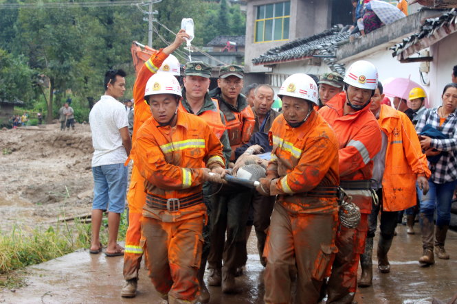 Lực lượng cứu hộ đưa người bị thương đi cứu chữa trong sáng 9-8 - Ảnh: REUTERS