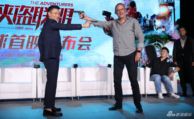 Lưu Đức Hoa tạo dáng đọ súng với diễn viên người Pháp Jean Reno - Ảnh: SINA