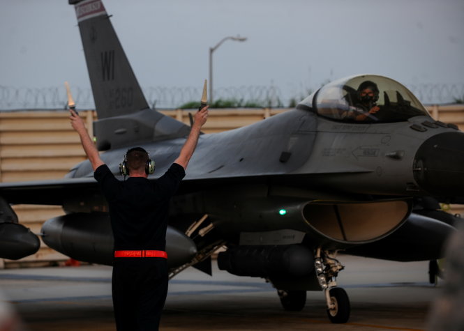 Binh sĩ Mỹ hướng dẫn chiếc F-16 của không quân Mỹ vừa được triển khai tại căn cứ không quân Kunsan ở Hàn Quốc ngày 3-8 - Ảnh: REUTERS