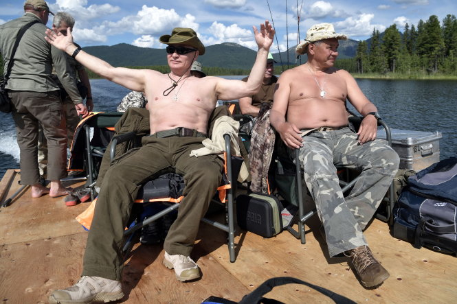 Tổng thống Putin (trái) cùng bộ trưởng Quốc phòng Sergei Shoigu cởi trần tắm nắng trong chuyến lái thuyền đi dạo hồ trên núi - Ảnh: REUTERS 