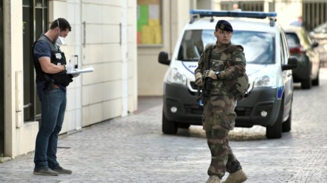 Lính vũ trang Pháp tuần tra bên cạnh một nhân viên cảnh sát gần khu vực đâm xe ở Levallois-Perret ngày 9-8 - Ảnh: AFP