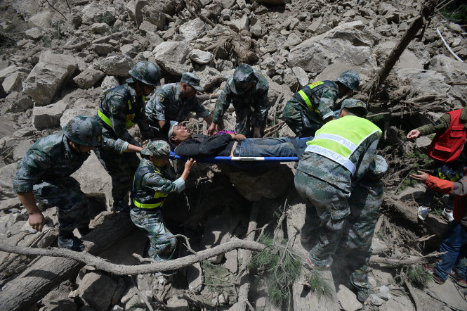 Nhân viên cứu hộ những người sống sót sau trận động đất hôm 8-8 - Ảnh: Reuters