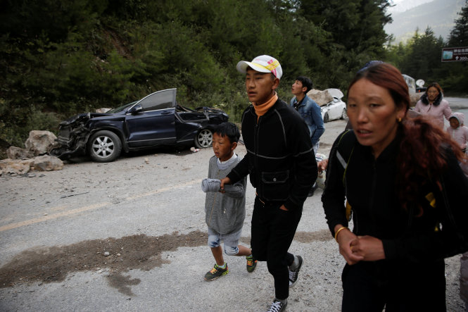 Người dân chạy dọc đường núi ở Cửu Trại Câu ngày 10-8 do lo lở đá - Ảnh: Reuters