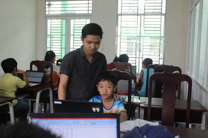 Nam sinh viên đang dạy tin học cho học sinh tiểu học tại Nhà Thiếu nhi tỉnh Bình Dương - Ảnh: CẨM TIÊN