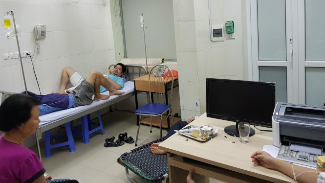 Do một số bệnh viện ở Hà Nội quá tải, phòng bác sĩ được trưng dụng làm phòng điều trị, người bệnh phải ngồi để truyền dịch - Ảnh: THÚY ANH