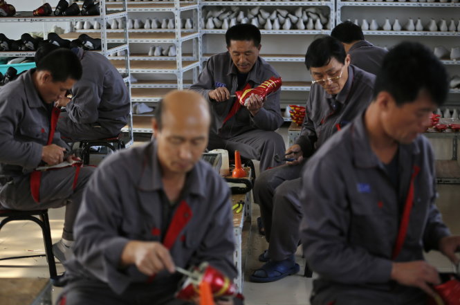 Công nhân Triều Tiên gia công giày thể thao trong một nhà máy tạm bợ ở tỉnh Liêu Ninh, Trung Quốc - Ảnh: REUTERS