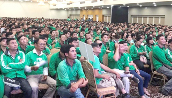 Hàng trăm tài xế GrabBike tập trung nghe hãng thông báo điều chỉnh chính sách tại một hội trường ở Hà Nội hôm 13-8.