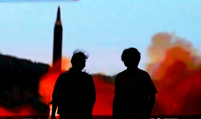 Người dân ở thủ đô Tokyo của Nhật theo dõi thông tin về hoạt động bắn thử tên lửa của Triều Tiên trên màn hình rộng - Ảnh: REUTERS