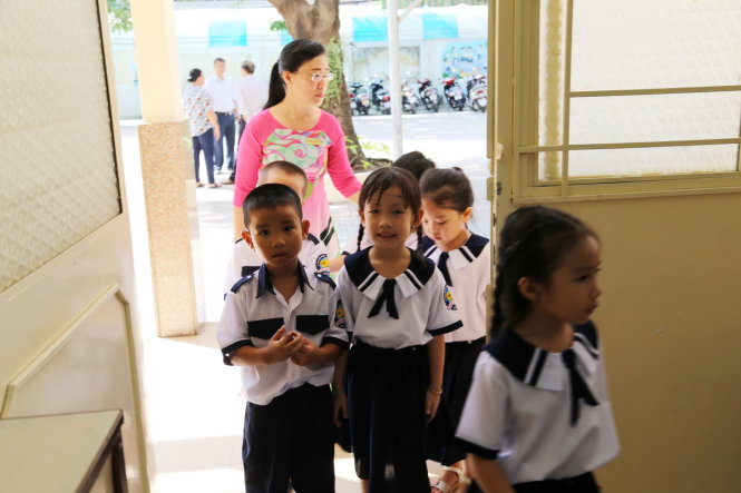 Cô Đặng Thùy Vân Anh đang hướng dẫn cách xếp hàng vào lớp cho học sinh lớp 1.1 Trường tiểu học Phan Đình Phùng Q3 - Ảnh: NHƯ HÙNG