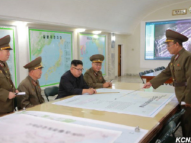 Nhà lãnh đạo Triều Tiên Kim Jong-un đang nghe trình bày về các kế hoạch tấn công đảo Guam của Mỹ bằng tên lửa đạn đạo - Ảnh: KCNA