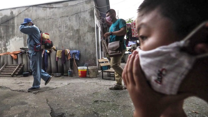 Nhân viên Trung tâm Y tế dự phòng Hà Nội phun hóa chất diệt muỗi tại một xóm trọ ở P.Định Công, Q.Hoàng Mai, Hà Nội  - Ảnh: NG.KHÁNH