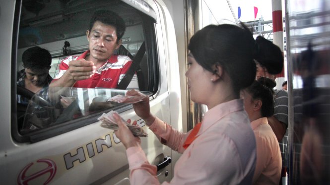 Chiều 14-8, tài xế đưa tiền lẻ khi qua trạm thu phí BOT Cai Lậy, Tiền Giang -  Ảnh: MẬU TRƯỜNG