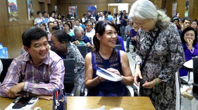 Chị Tim (giữa) tặng sách cho cô Kim Cúc - người cộng sự từ những ngày đầu thành lập Nhà May Mắn - Ảnh: L.Điền